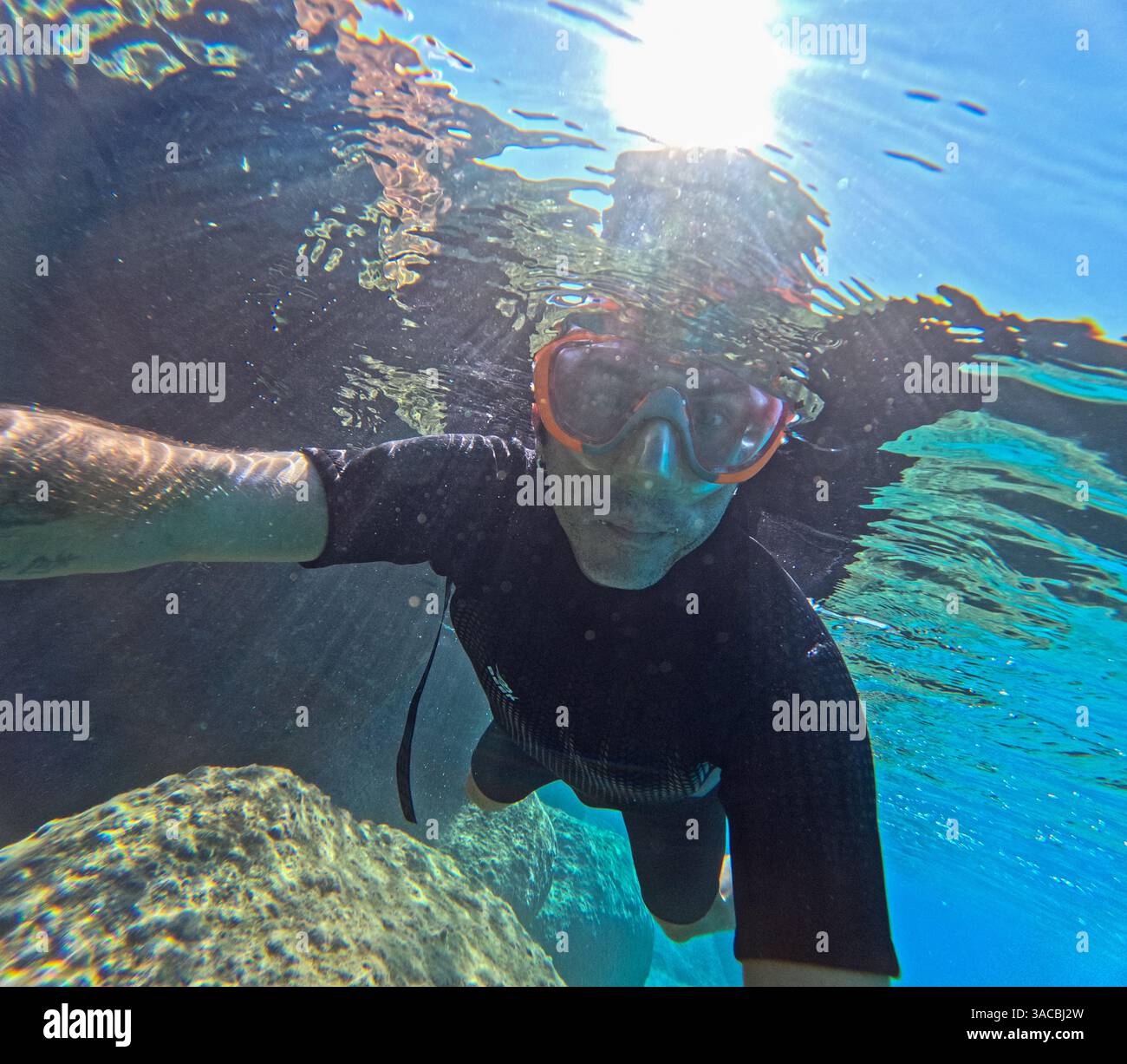 L'uomo nuota sott'acqua nel Mar Mediterraneo. L'uomo ha quarant'anni e di origine caucasica Foto Stock