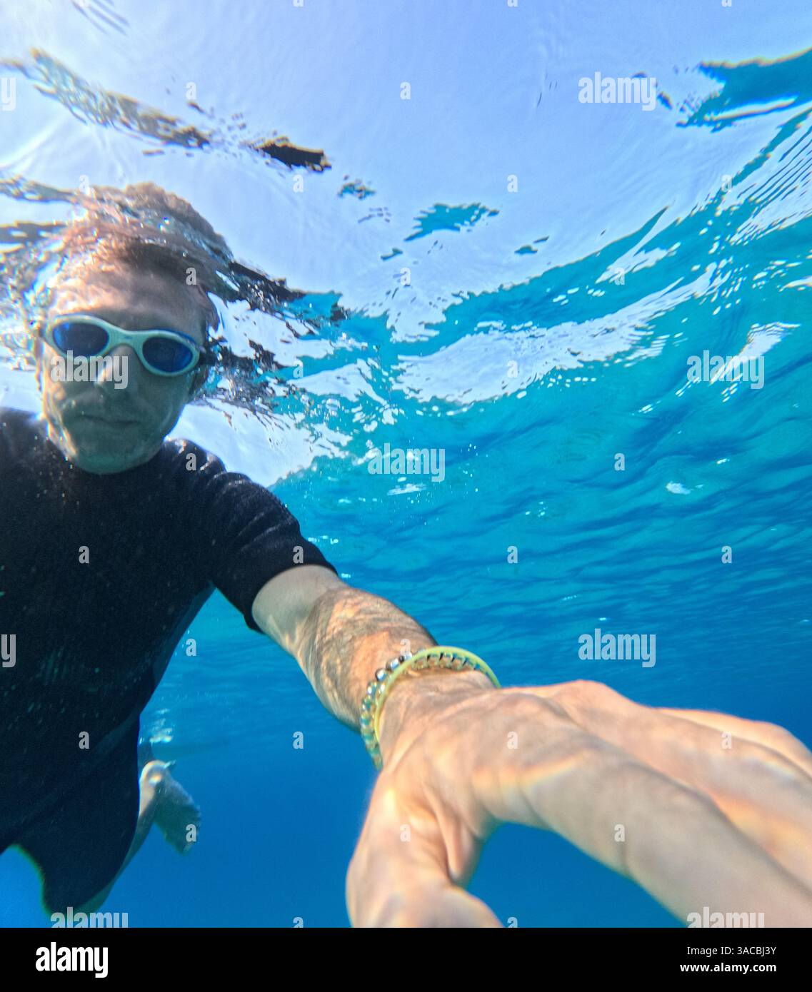 L'uomo nuota sott'acqua nel Mar Mediterraneo. L'uomo ha quarant'anni e di origine caucasica Foto Stock