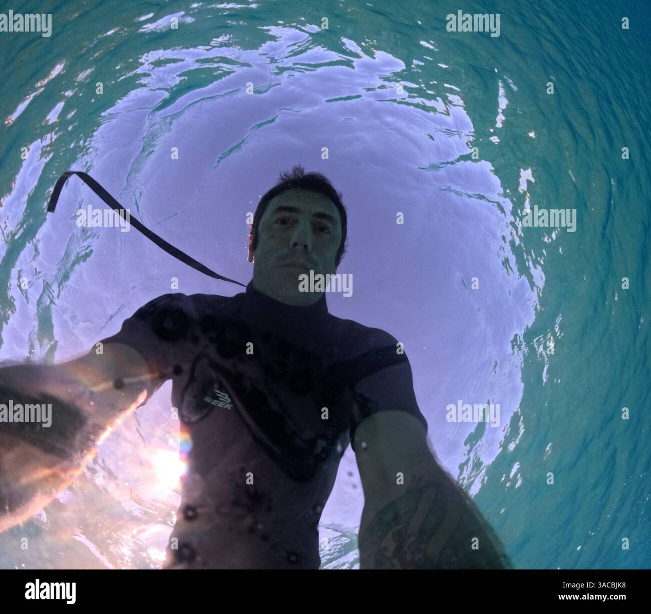 L'uomo nuota sott'acqua nel Mar Mediterraneo. L'uomo ha quarant'anni e di origine caucasica Foto Stock