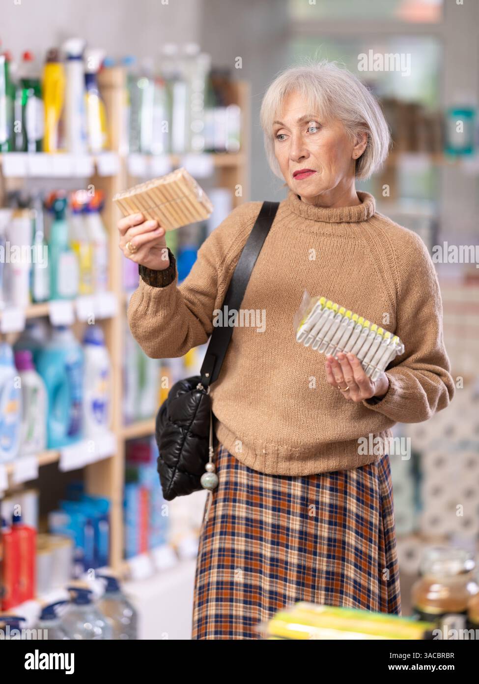 Donna che sceglie un set di clothespins nel negozio Foto Stock