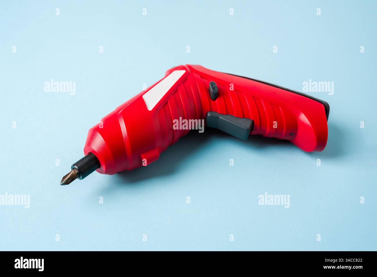 Vista dall'alto del mini avvitatore a batteria rosso su sfondo blu Foto Stock