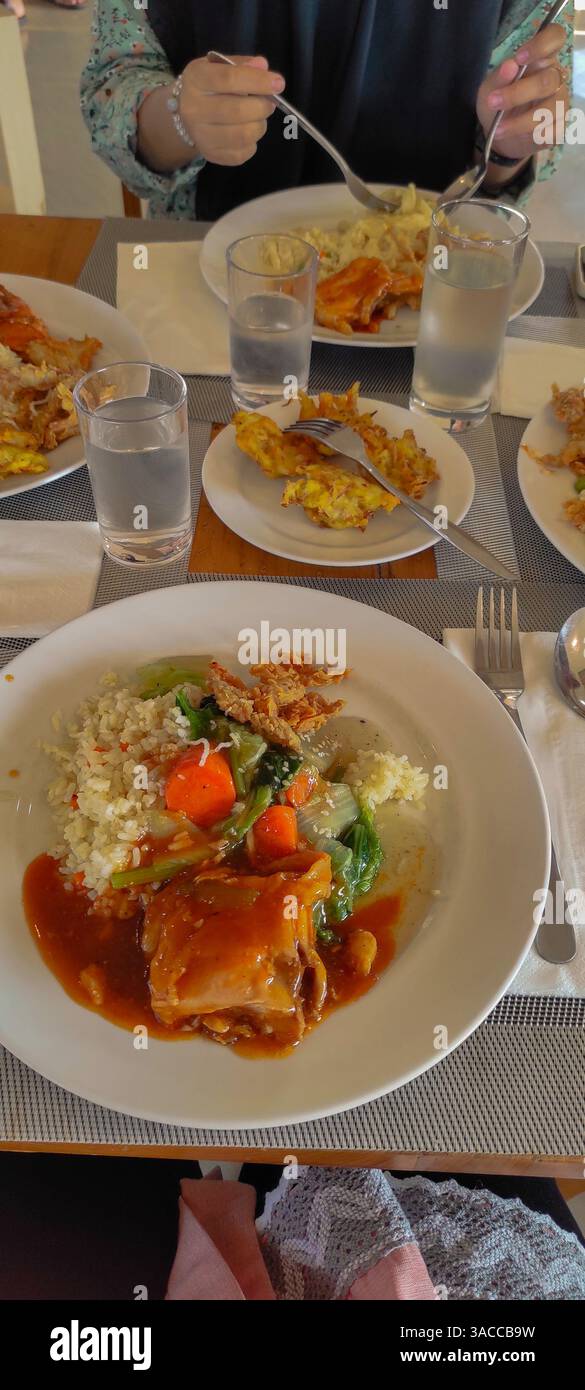 ambiente rilassato con piatti di riso, zuppa di verdure e spiedini di frutta rinfrescanti, ideale per un incontro amichevole o un pasto in famiglia Foto Stock