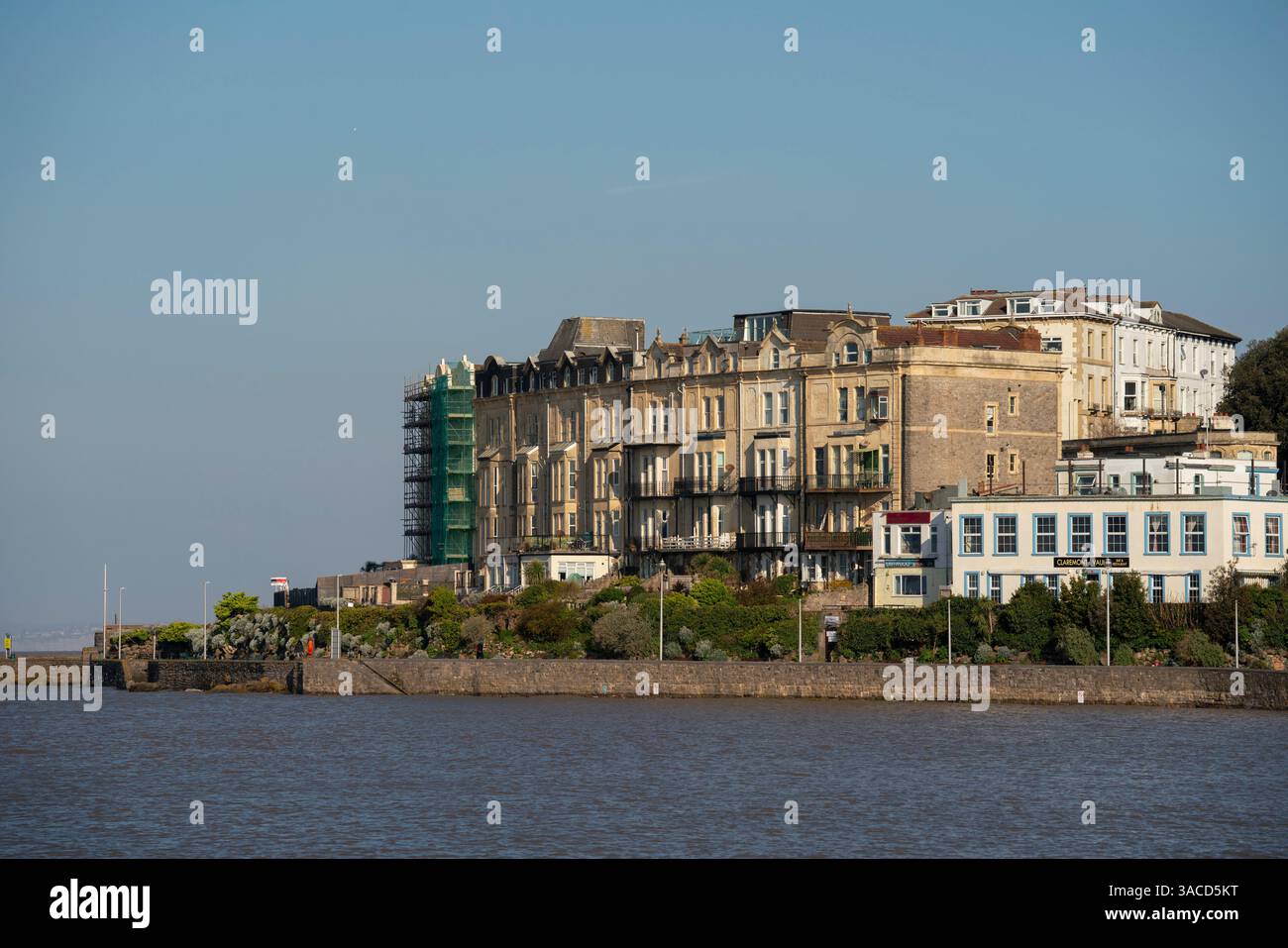 Alloggi lungo il lungomare di Weston-super-Mare in una giornata di sole e limpido con l'alta marea primaverile. Foto Stock