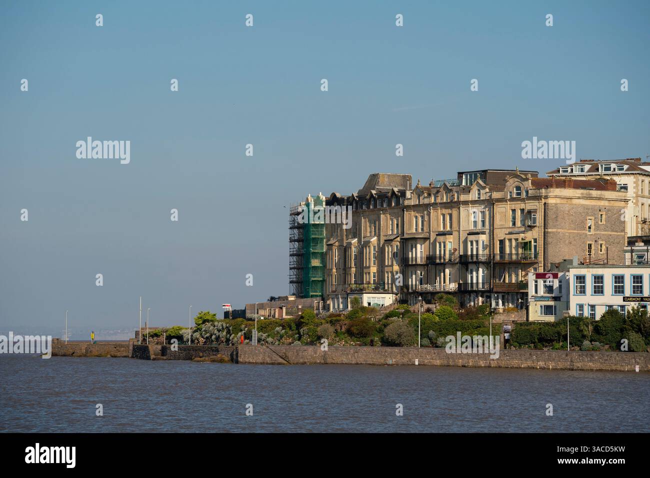 Alloggi lungo il lungomare di Weston-super-Mare in una giornata di sole e limpido con l'alta marea primaverile. Foto Stock