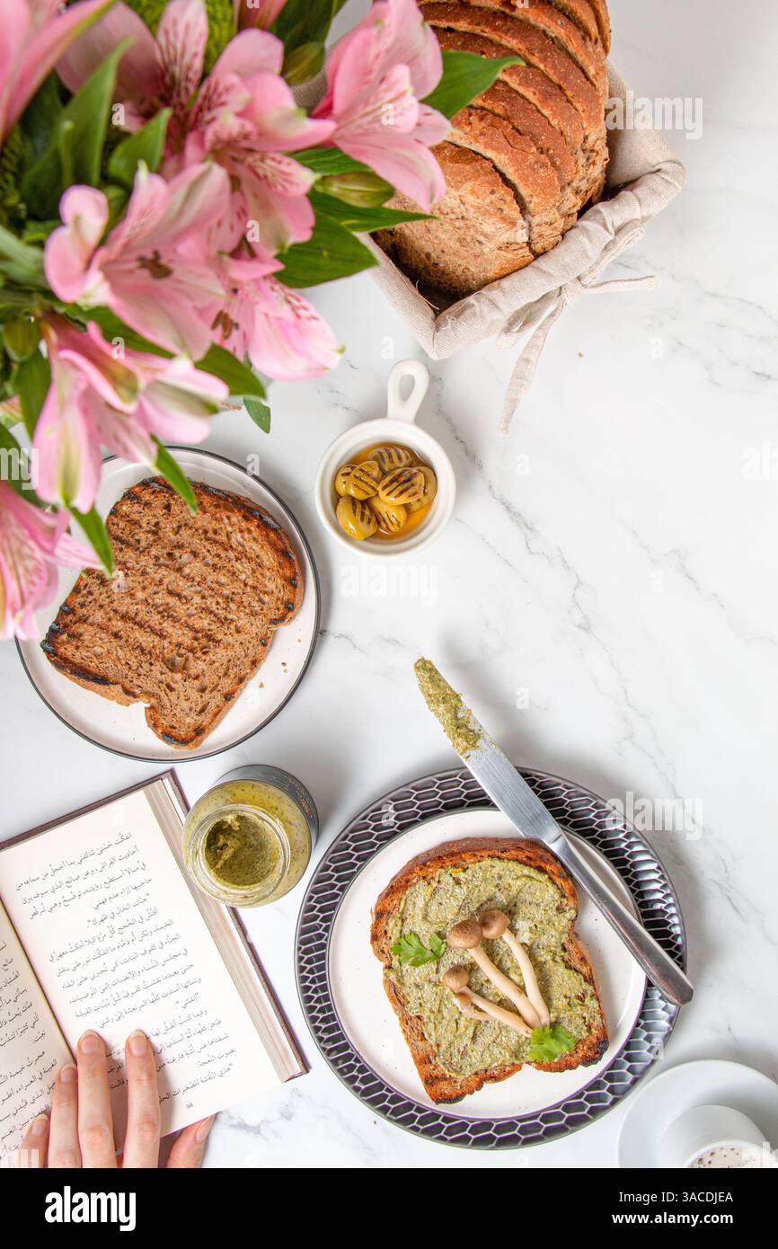 Vivace colazione a base di piante con frutta fresca, verdura e pane integrale – vibrazioni mattutine con fiori Foto Stock