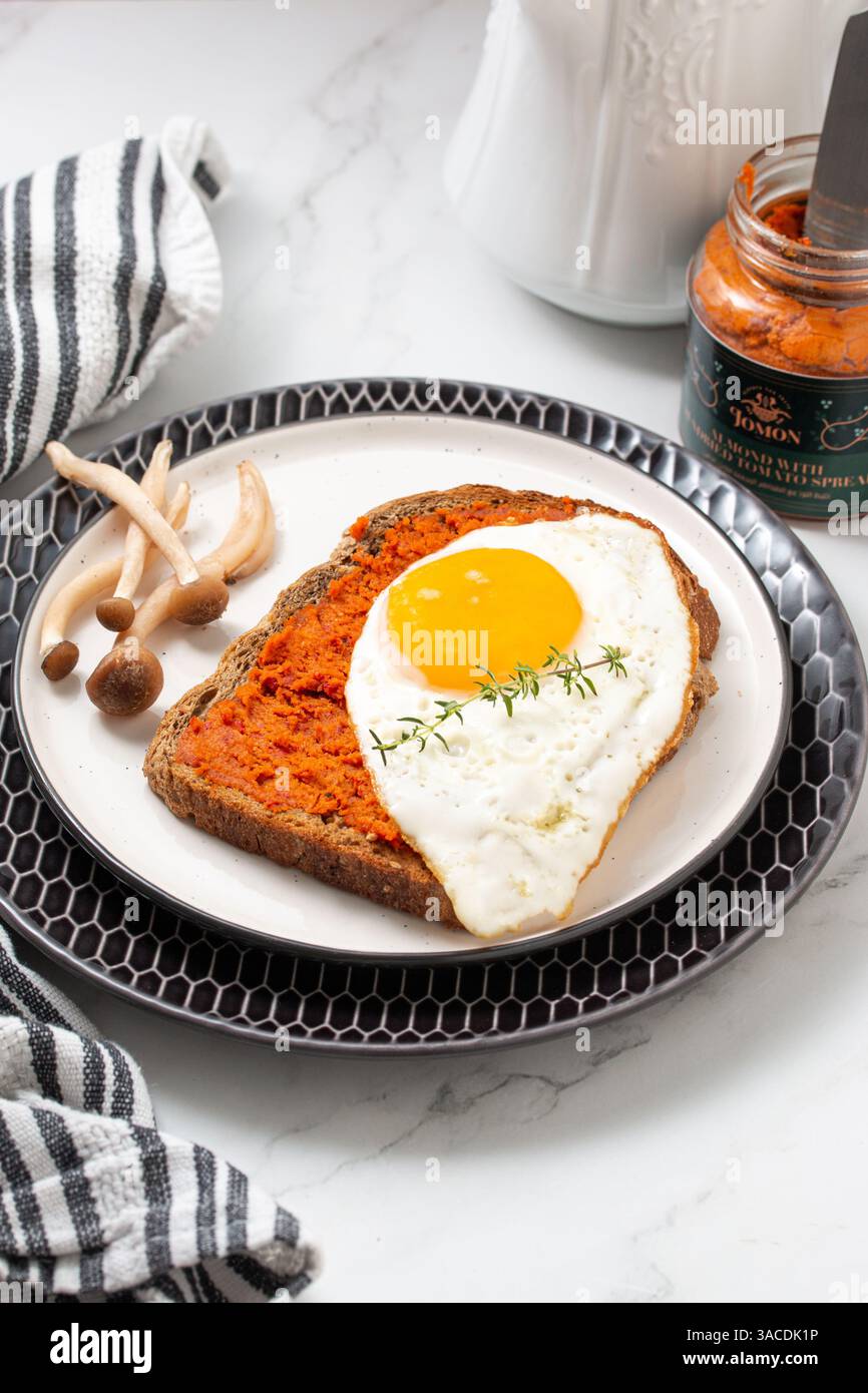 Vivace colazione a base di piante con frutta fresca, verdura e pane integrale – vibrazioni mattutine con fiori Foto Stock