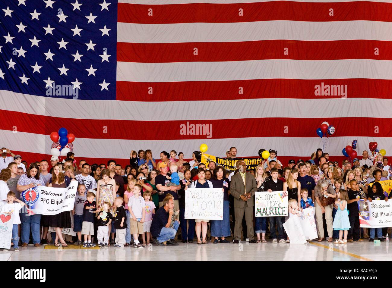 30 marzo 2008 - Phoenix, Arizona, Stati Uniti - i membri della famiglia dei soldati della Guardia Nazionale dell'Arizona aspettano che i loro cari tornino a casa dall'Afghanistan su un gancio dell'Aeronautica militare a Phoenix, Arizona, domenica. Circa 250 membri del 158th Infantry Battalion della Guardia Nazionale dell'Arizona sono tornati a Phoenix, Arizona, da un anno di schieramento in Afghanistan Sunday. L'unità, nota anche come "Bushmasters" dal loro servizio nella seconda guerra mondiale, faceva parte del più grande dispiegamento monounità della Guardia nazionale dell'Arizona dalla seconda guerra mondiale. Due membri del battaglione sono stati uccisi in azione durante il loro d Foto Stock
