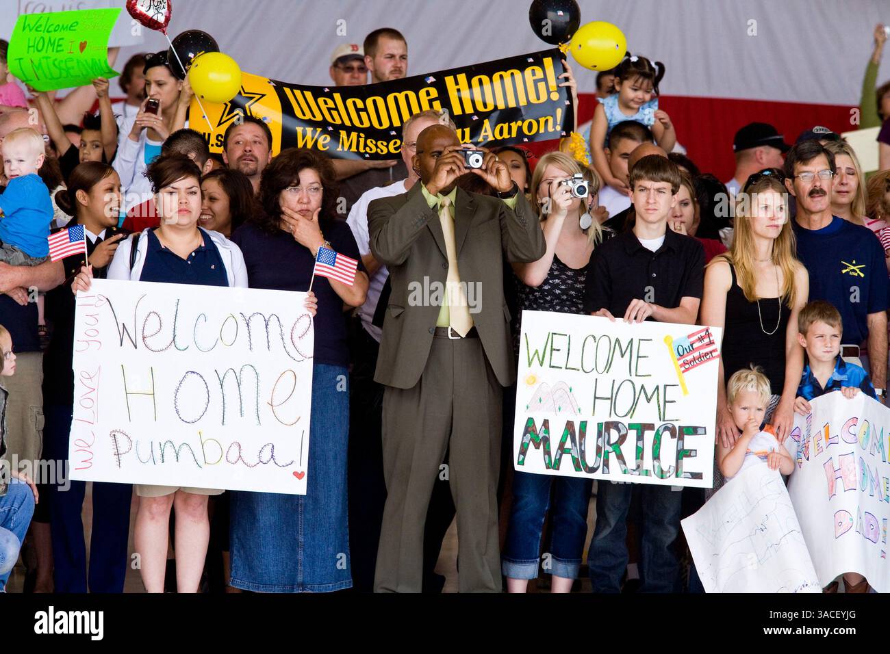 30 marzo 2008 - Phoenix, Arizona, Stati Uniti - i membri della famiglia dei soldati della Guardia Nazionale dell'Arizona aspettano che i loro cari tornino a casa dall'Afghanistan su un gancio dell'Aeronautica militare a Phoenix, Arizona, domenica. Circa 250 membri del 158th Infantry Battalion della Guardia Nazionale dell'Arizona sono tornati a Phoenix, Arizona, da un anno di schieramento in Afghanistan Sunday. L'unità, nota anche come "Bushmasters" dal loro servizio nella seconda guerra mondiale, faceva parte del più grande dispiegamento monounità della Guardia nazionale dell'Arizona dalla seconda guerra mondiale. Due membri del battaglione sono stati uccisi in azione durante il loro d Foto Stock