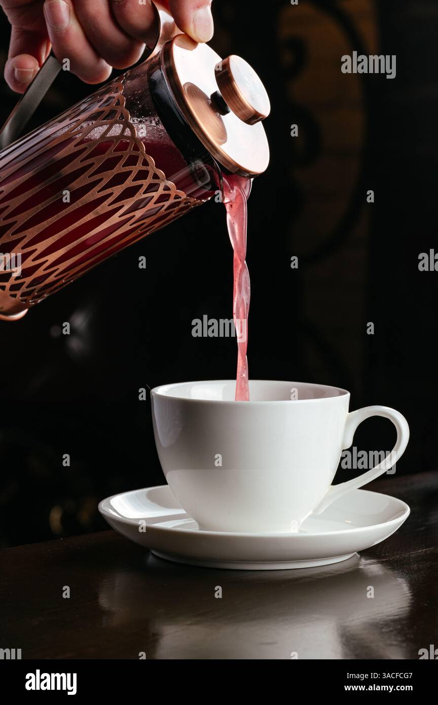 il succo di frutti di bosco viene versato in una tazza Foto Stock