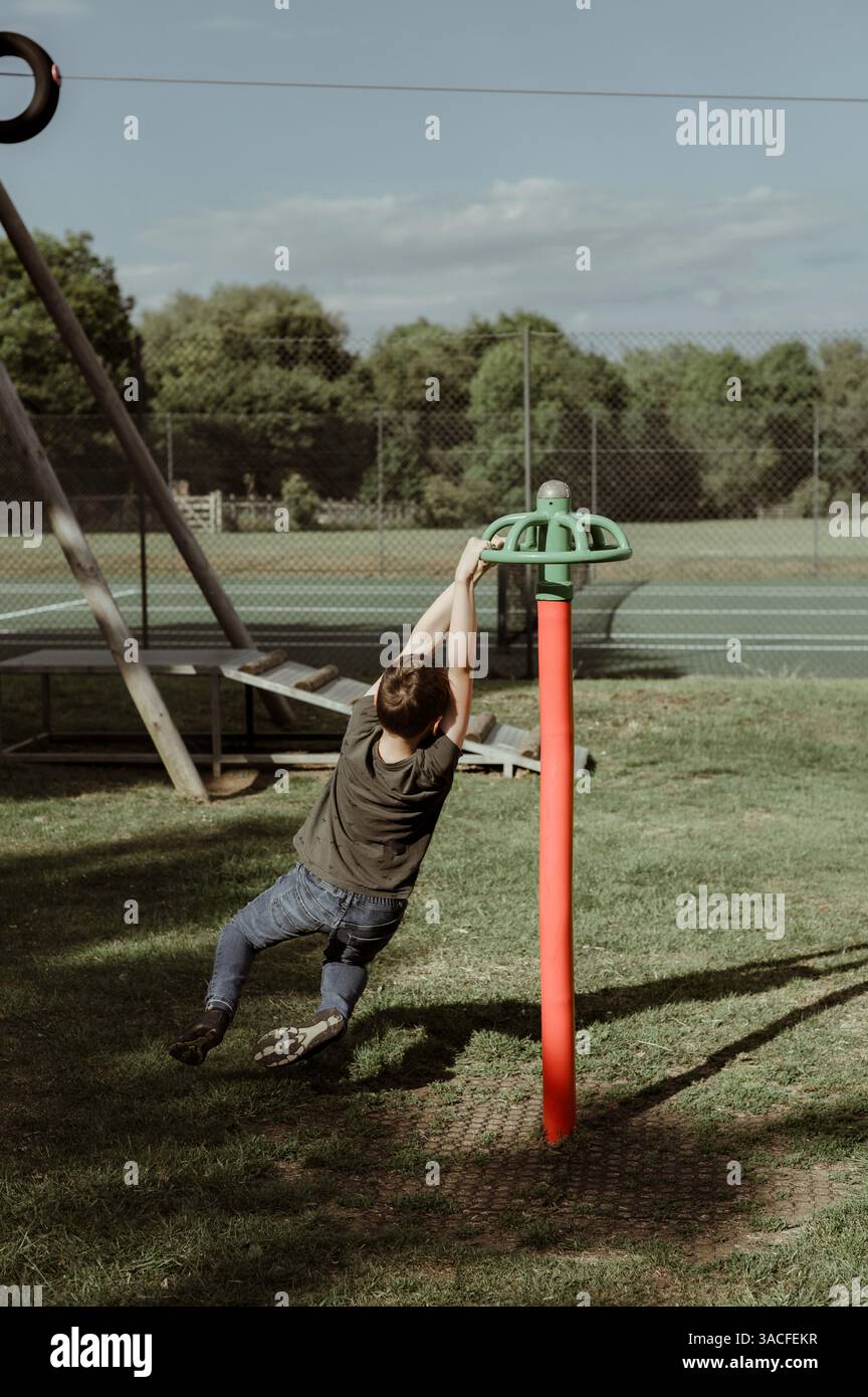 Ragazzo al parco giochi. gira sull'attrezzatura del parco giochi. Foto Stock