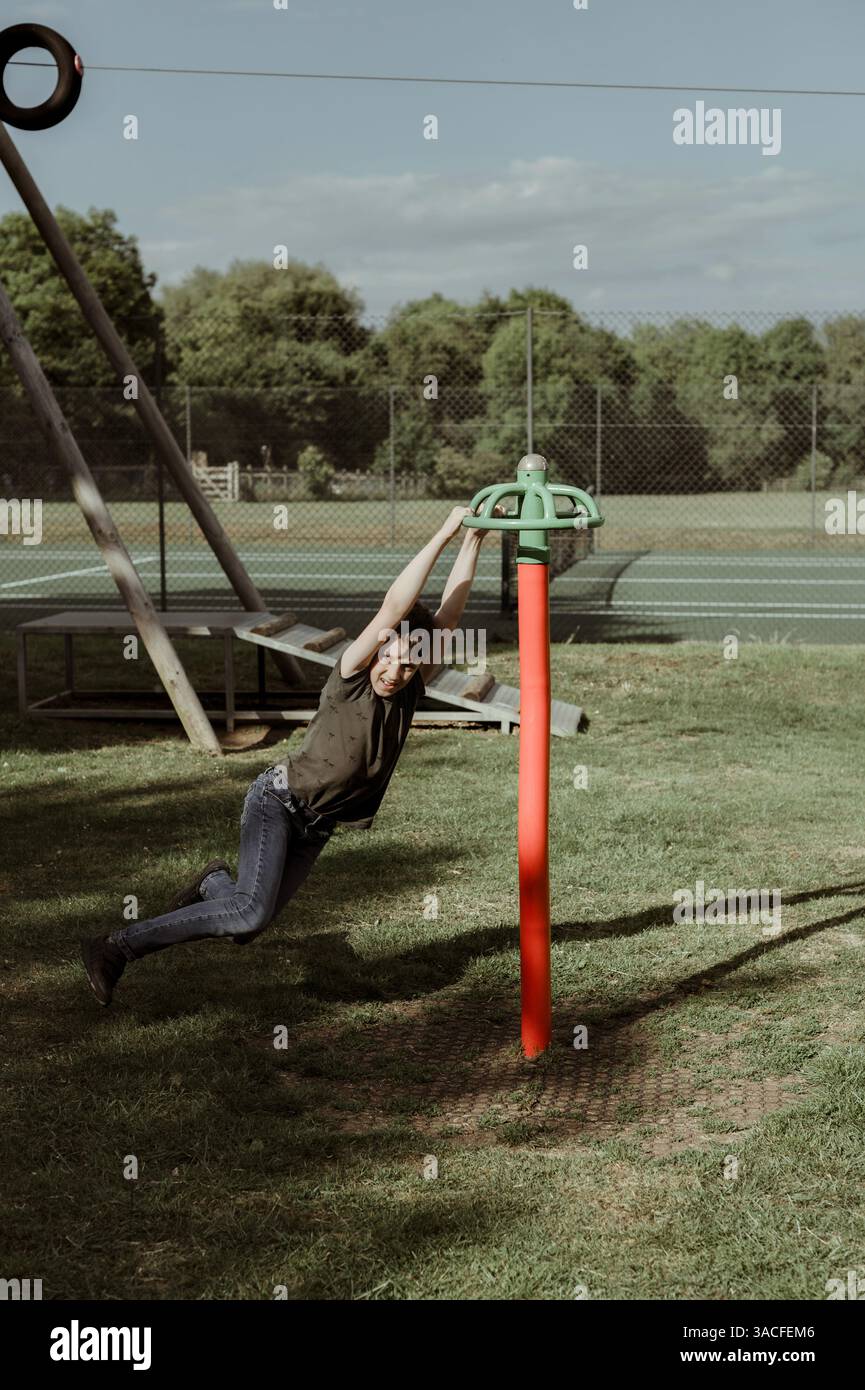 Ragazzo al parco giochi. gira sull'attrezzatura del parco giochi. Foto Stock