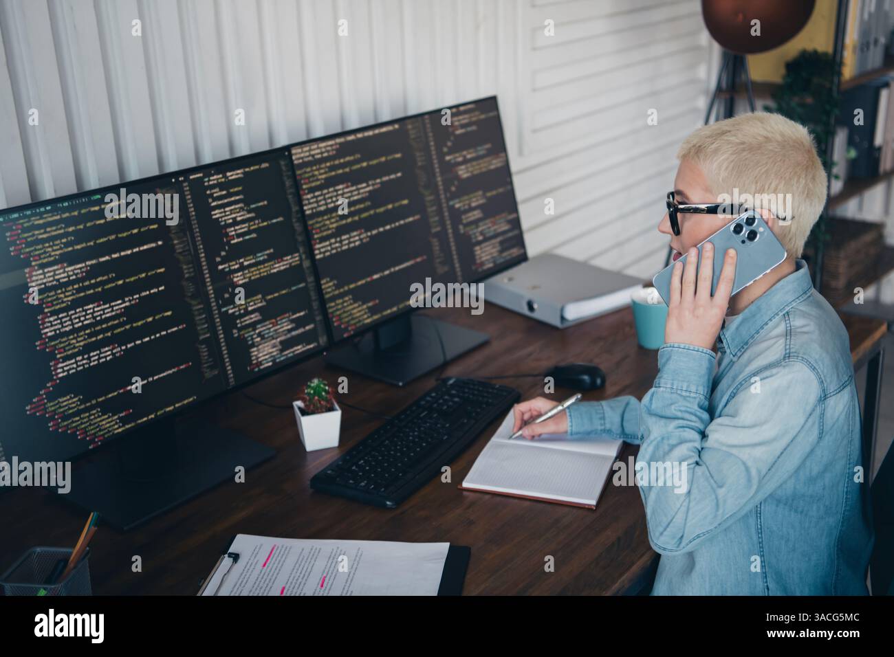 Programmatore donna che lavora in remoto utilizzando strumenti e tecnologie di codifica in un moderno ambiente di home Office Foto Stock