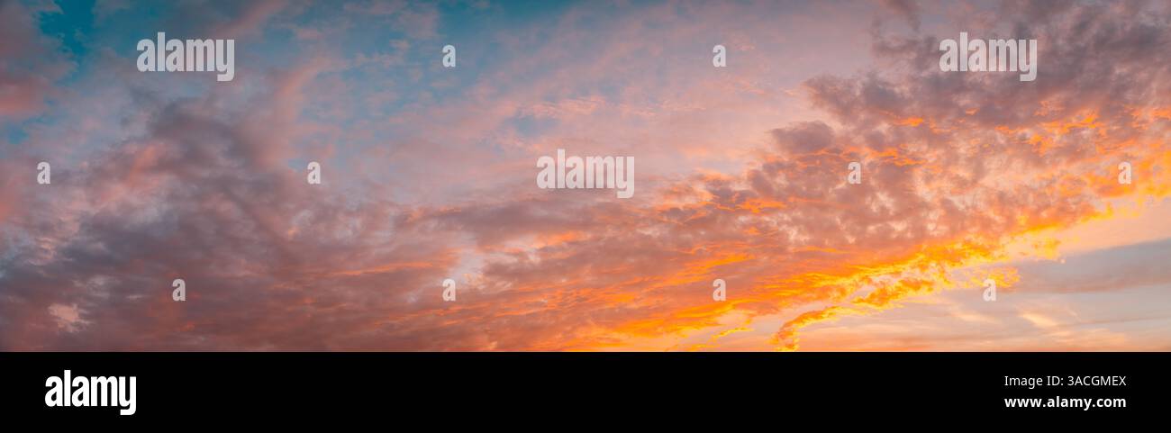Meravigliose nuvole di rosa arancio tenue al tramonto dai toni pastello. Cielo con un clima sereno. Splendida carta da parati. Cielo epico luminoso pano luminoso per la sera Foto Stock