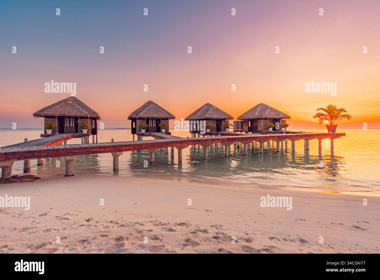 Incredibile panorama sulla spiaggia. Splendida vista sul mare al tramonto delle Maldive. Orizzonte colorato cielo nuvole mare, sopra acqua villa molo sentiero. Tranquillo Foto Stock