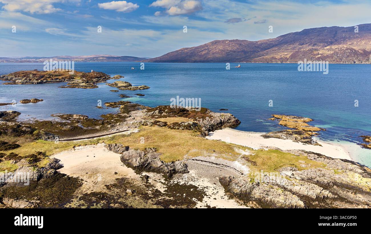 Sandaig Islands and Bay in Kyle Rhea, Scozia, una barca che passa per le isole e il faro bianco Foto Stock