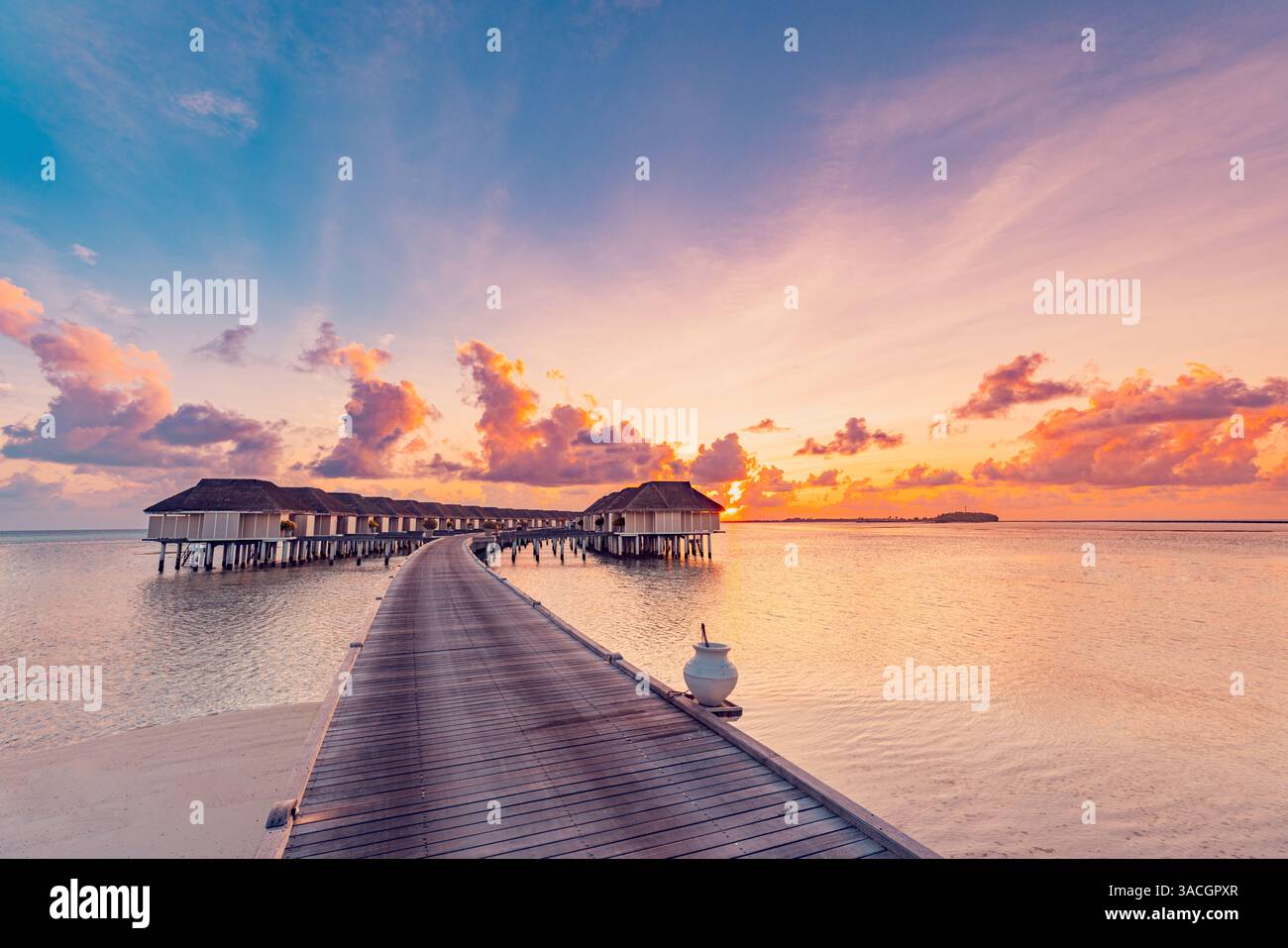 Incredibile panorama sulla spiaggia. Splendida vista sul mare al tramonto delle Maldive. Orizzonte colorato cielo nuvole mare, sopra acqua villa molo sentiero. Tranquillo Foto Stock
