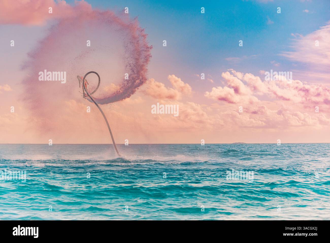 Silhouette di un pilota di fly board in mare. I piloti professionisti fanno dei trucchi nella laguna blu. Attrezzature per sport acquatici tropicali. Flyboard all'aperto estremo Foto Stock