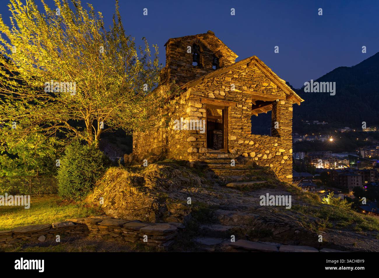 La storica chiesa romanica di Sant Romà de les Bons ad Andorra, splendidamente illuminata al crepuscolo. Questa struttura in pietra sorge su una collina che domina il traino Foto Stock