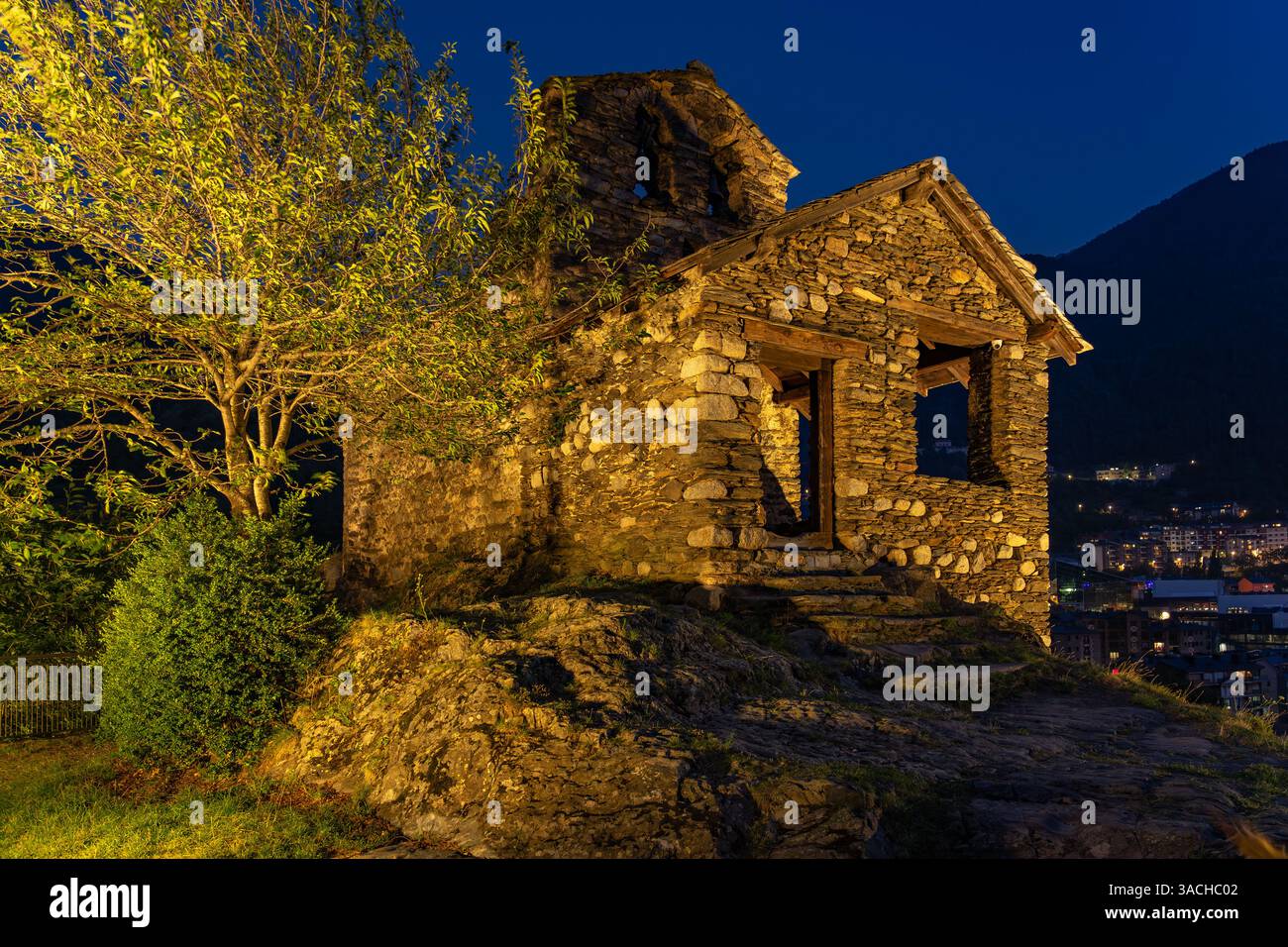 La storica chiesa romanica di Sant Romà de les Bons ad Andorra, splendidamente illuminata al crepuscolo. Questa struttura in pietra sorge su una collina che domina il traino Foto Stock