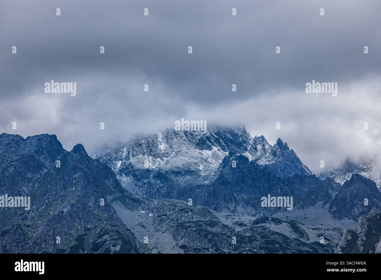 Splendida vista sulle montagne coperte da nuvole. Spettacolari nuvole di cielo, cime innevate con vista panoramica. Paesaggio artistico escursionistico, sfondo astratto Foto Stock