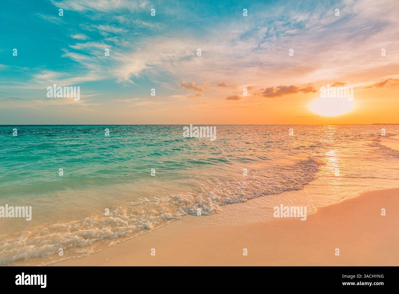 Il cielo del tramonto dorato nuvole di tranquille spiagge marine, le onde calme spruzzano dolcemente la riva, l'orizzonte tranquillo illumina la calda luce del sole serale, la tranquilla scena dell'oceano Foto Stock