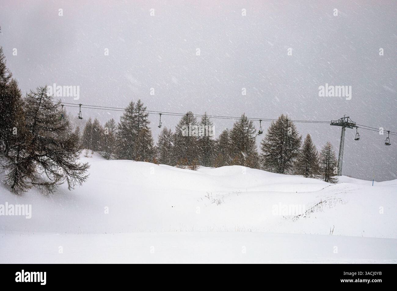 Neve con pioggia e vento sulla cima di una montagna in una stazione sciistica italiana nelle Alpi. Scarsa visibilità Foto Stock