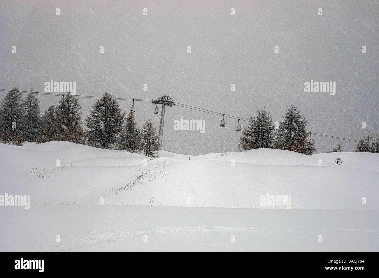 Neve con pioggia e vento sulla cima di una montagna in una stazione sciistica italiana nelle Alpi. Scarsa visibilità Foto Stock