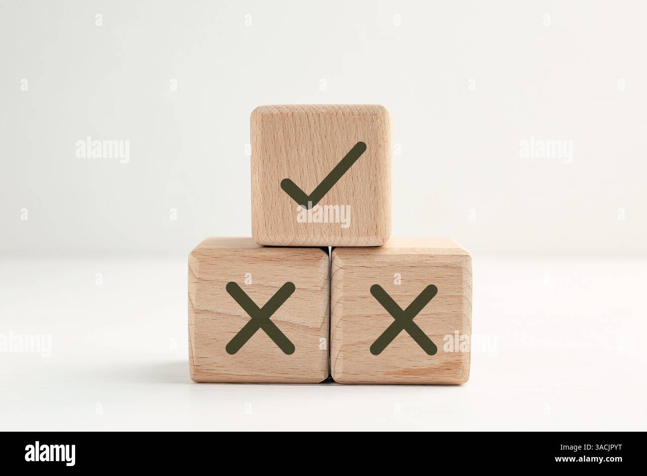 Approvazione del rifiuto. Cubi in legno con segni a scacchi e a croce su sfondo bianco Foto Stock