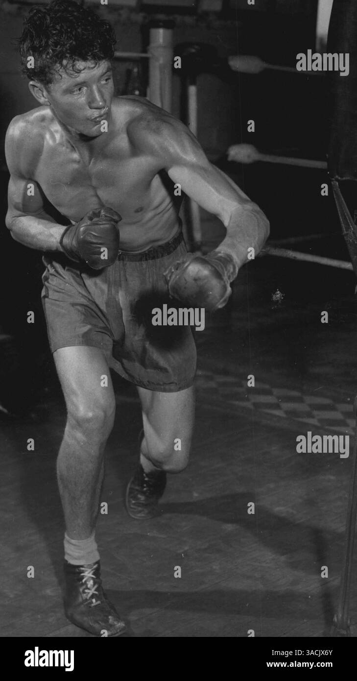 L'ex campione britannico dell'Empire Welter Barry Brown incontra Dave Clingan allo stadio lunedì sera. Barry Brown, che combatte contro Dave Clingan allo stadio stasera, mette un sacco di vim in allenamento con la pesante borsa di pugni. 16 ottobre 1955. Foto Stock