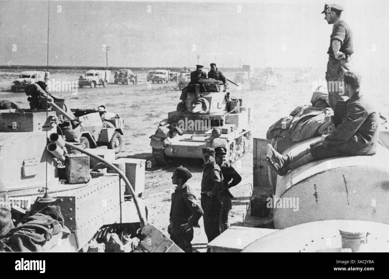 Rifornimento in prima linea - mentre le ambulanze della croce rossa e i camion di rifornimento sono in attesa, i carri armati britannici assumono un carico pieno da un camion a benzina sulla destra, a soli 800 metri di distanza dall'abbaiare i cannoni tedeschi. Durante la battaglia per Sidi Barrani in Egitto. Durante le operazioni di rifornimento gli aerei da caccia tedeschi attaccarono i veicoli, ma furono dispersi da aerei R.A.F. 2 dicembre 1942. (Foto di AP Wirephoto). Foto Stock