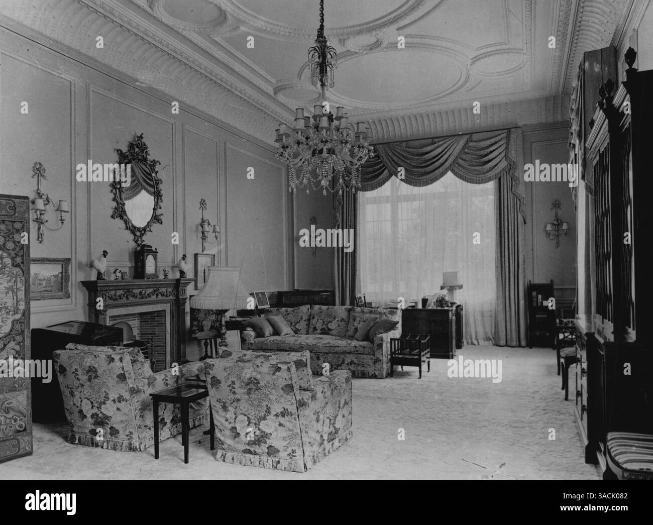 Clarence House -- sua altezza reale la principessa Elisabetta ***** Salotto. Si trova al primo piano ed è arredato interamente con regali nuziali. Il soffitto e' uno di quelli progettati da Nash ***** Per il Duca di Clarence nel 1885. Il ***** Il camino scolpito del diciottesimo secolo proviene da Kensington Palace. I pozzi sono dipinti di blu acquamarina. Il ***** Con un design di colore rosa e bianco gli Hollyhocks sono **** il colore delle pareti e i cuscini di ***** Rosso lacca le tende delle finestre di dune a motivi geometrici si abbinano alle pareti. La modalità ***** Il tappeto Chineses e' di lana color seif **** e wome Foto Stock