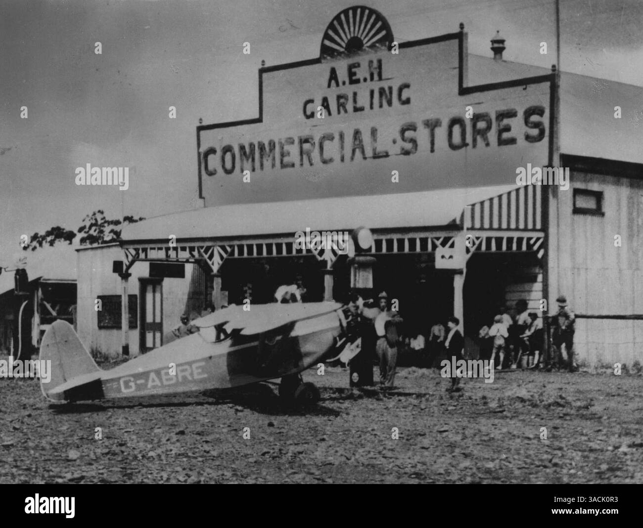Nella fase finale di un volo record Inghilterra-Australia di 9 giorni, 1 ora e 43 minuti nel 1933, Arthur Butler ora (1953) amministratore delegato della terza compagnia aerea nazionale australiana Butler Air Transport Pty. Ltd. -- ha rifornito il suo compter Swift monoplano per le strade della cittadina di Tooraweena nel New South Wales. La figlia del proprietario del negozio in seguito divenne sua moglie. 30 novembre 1955. (Foto di John Tanner, fotografia ufficiale australiana) Foto Stock