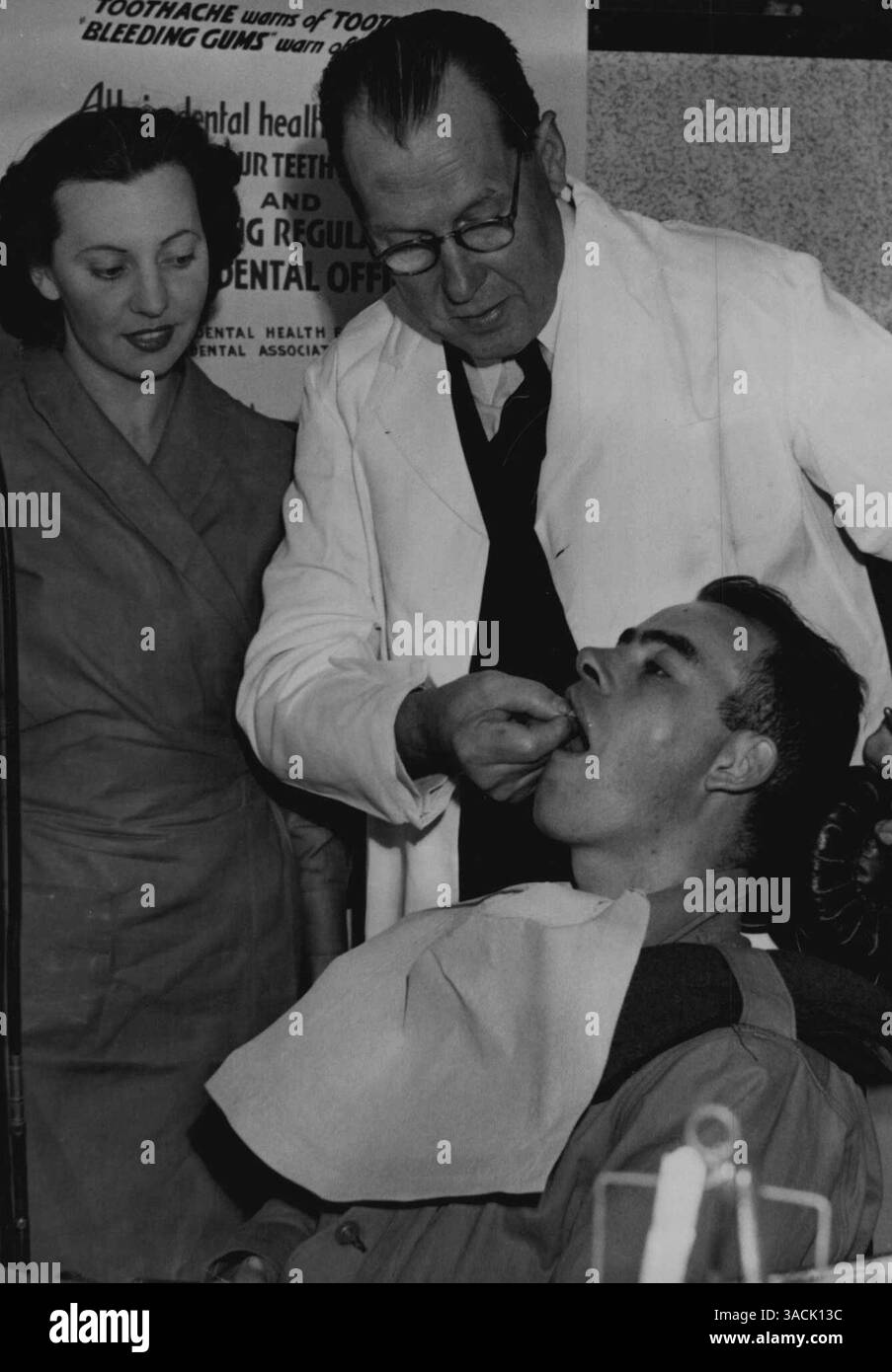 1° giorno di nuovo schema odontoiatrico allo Showgard. Infermiera Jeanne Ellery e Dr. George Donkin al lavoro su Private V. Brddberg. 1° luglio 1940. (Foto di Paul Stephen Pearson/Fairfax Media). Foto Stock