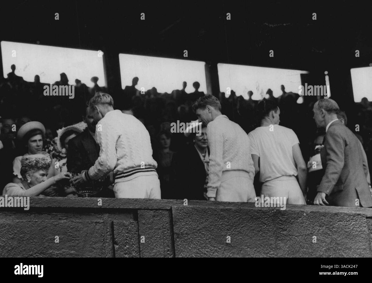 Queen Mary presenta la Wimbledon Double Cup. Londra: La regina Mary, seduta nel palco reale, regala il trofeo del doppio maschile ai vincitori australiani - John Bromwich (coppa ricevente) e F. Sedgman - dopo la vittoria del Centre Court contro gli americani, Tom Brown e Gardner Mulloy. Gli australiani hanno vinto 5-7: 7-5: 7-5: 9-7. 3 luglio 1948. Foto Stock