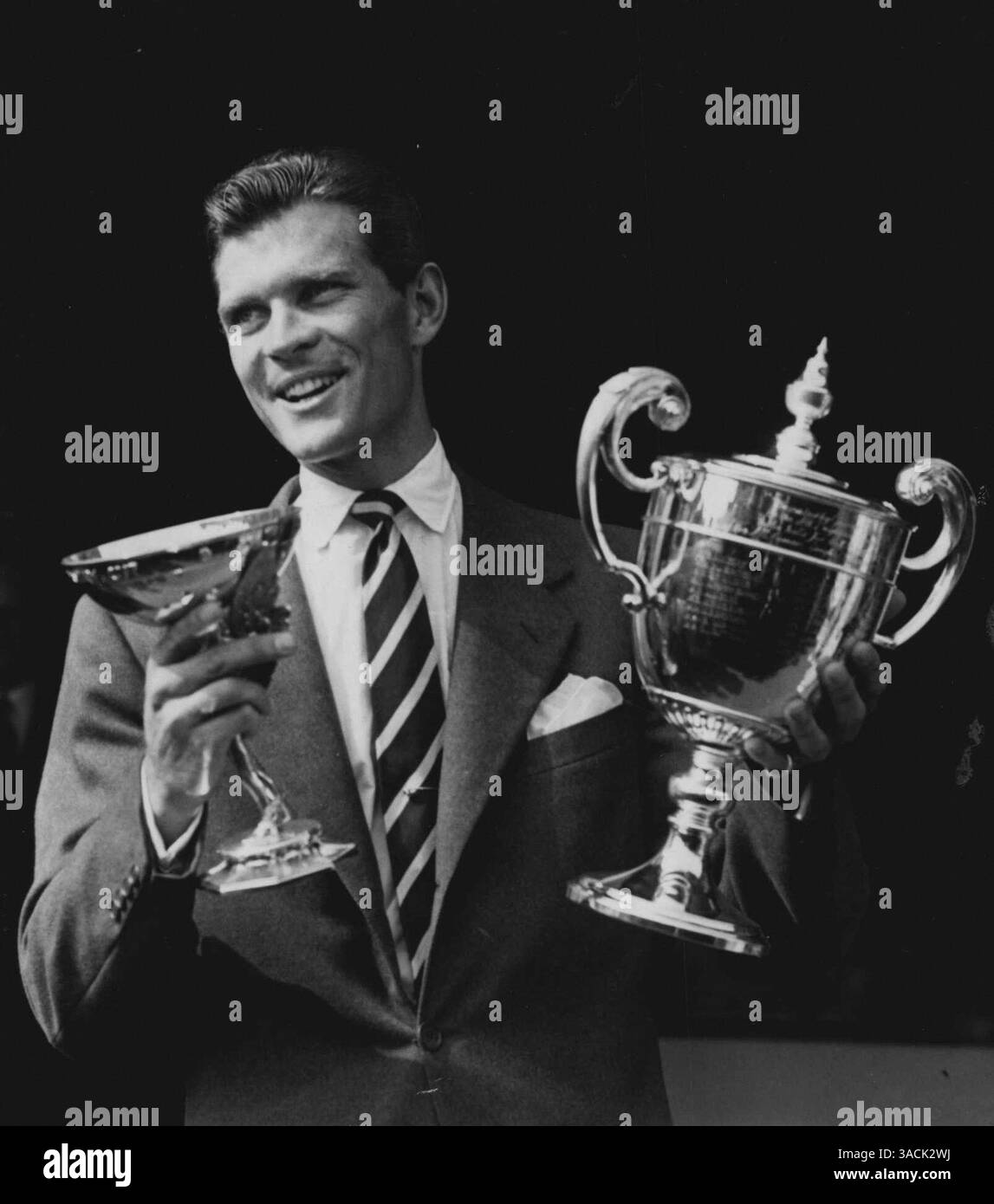 Patty vince Wimbledon Singles Beats Sedgman in un combattimento faticoso. Un primo piano del vittorioso Budge Patty degli Stati Uniti, che ha vinto oggi i campionati di Wimbledon Mens Singles (venerdì). Ha battuto l'australiano Frank Sedgman 6-1, 8-10, 6-2, 6-3. Patty e' stato con le sue coppe dopo la finale. American Budge Patty sorprende trionfalmente mentre mostra i suoi trofei per il campionato singolo di Wimbledon. Patty ha battuto Sedgman nella finale di venerdì scorso. 7 luglio 1950. (Foto di Fox Photos) Foto Stock