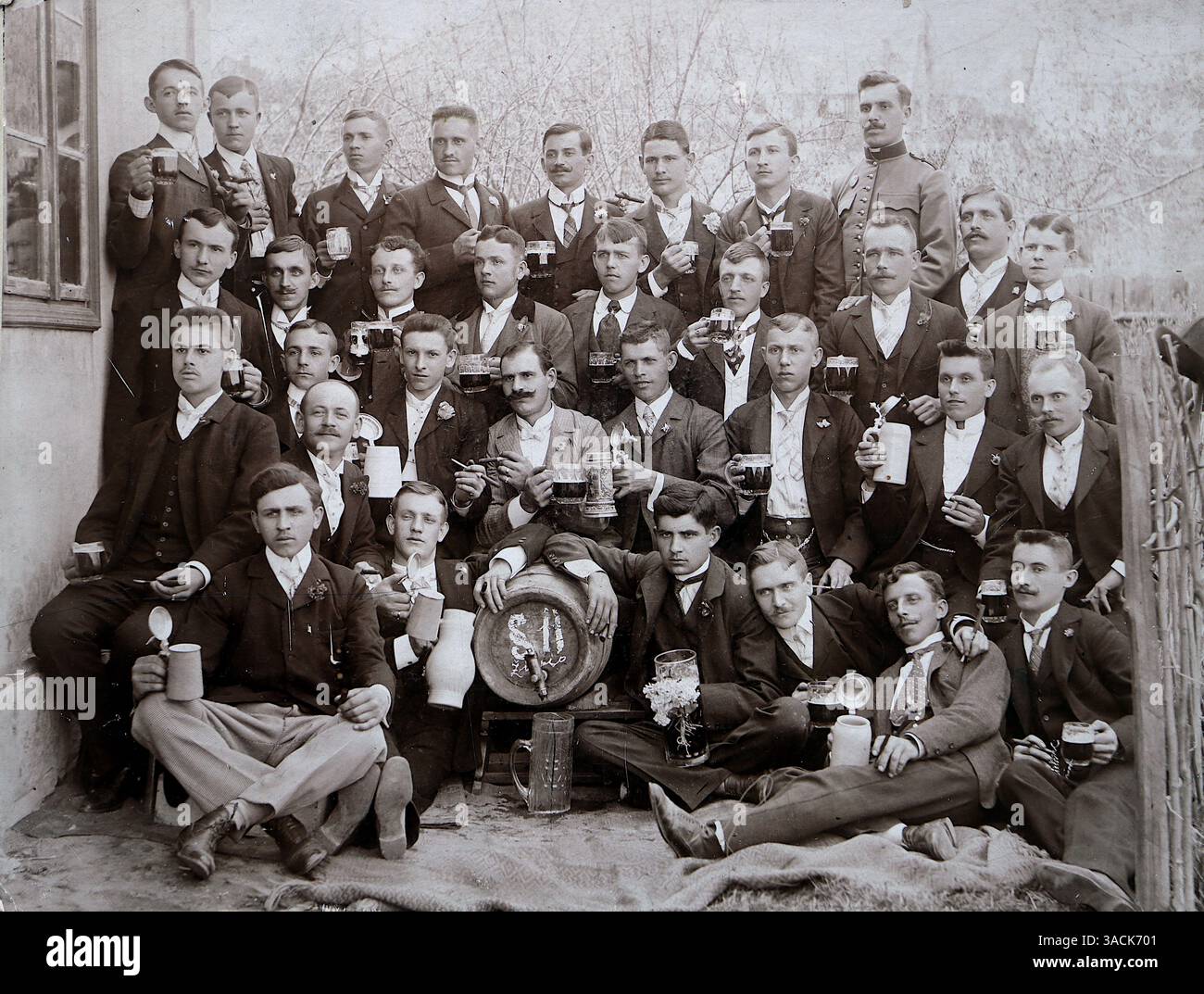Bosnia, c1909. Un gruppo di giovani uomini in abbigliamento formale, compresi abiti e cravatta. Le tazze e le bistecche da birra suggeriscono un incontro sociale, che era un aspetto comune della cultura bosniaca all'epoca. Forse in relazione a una fraternità o a un club sociale. Da una fotografia originale di J. Hampl di Zenica, Bosnia. Nel 1909, Zenica faceva parte dell'Impero austro-ungarico, che aveva annesso la Bosnia ed Erzegovina nel 1908. La regione era amministrativamente governata sotto il dominio austro-ungarico. L'annessione fu un evento significativo nella storia europea, contribuendo alle tensioni che alla fine portarono alla prima guerra mondiale. Foto Stock