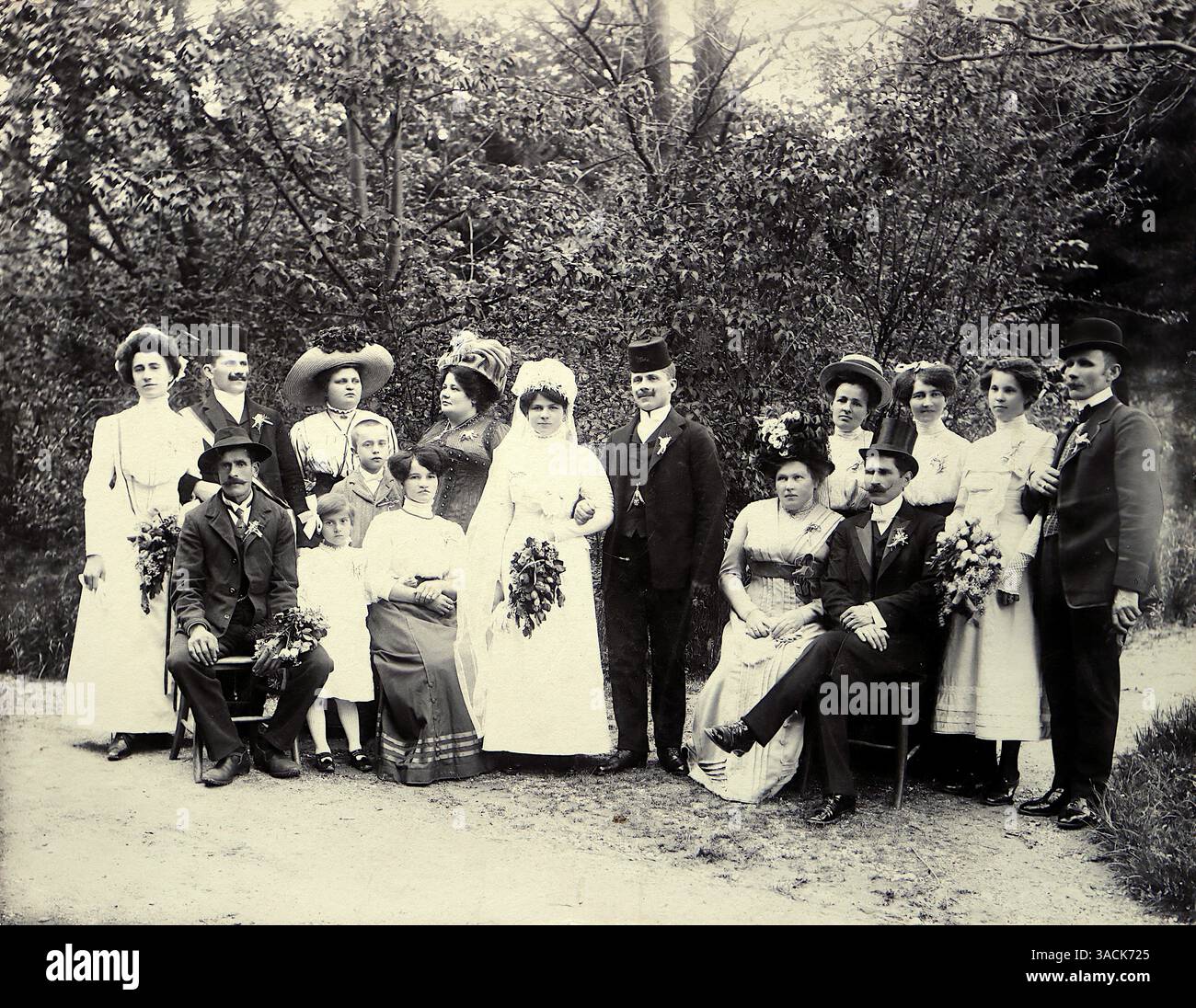 Bosnia, c1909. Un gruppo di nozze in abbigliamento formale, compresi abiti lunghi con cappelli per donne e abiti con cappelli per uomini, tipici degli stili influenzati sia dalla modernizzazione austro-ungarica che dagli elementi tradizionali balcanici. Da una fotografia originale di J. Hampl di Zenica, Bosnia. Nel 1909, Zenica faceva parte dell'Impero austro-ungarico, che aveva annesso la Bosnia ed Erzegovina nel 1908. La regione era amministrativamente governata sotto il dominio austro-ungarico a quel tempo. L'annessione fu un evento significativo nella storia europea, contribuendo alle tensioni che alla fine portarono alla prima guerra mondiale. Foto Stock