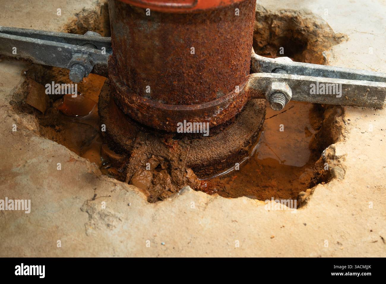 Perdite dal tubo o acqua stagnante intorno a un tubo in calcestruzzo. Primo piano. Sfondo impianto idraulico. Possibile perdita d'acqua intorno al vecchio tubo arrugginito nella sala di servizio o nel bagno d'acqua Foto Stock