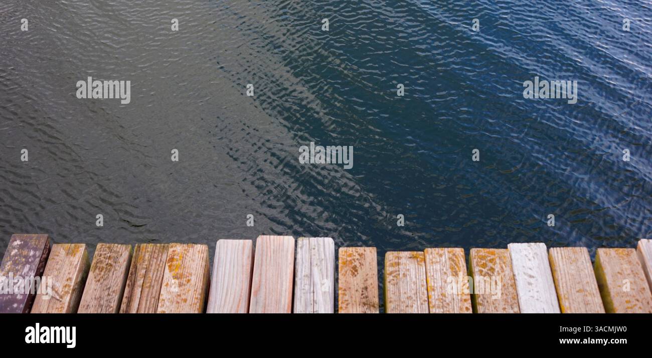 Molo di legno con tavole di legno su un lago Foto Stock