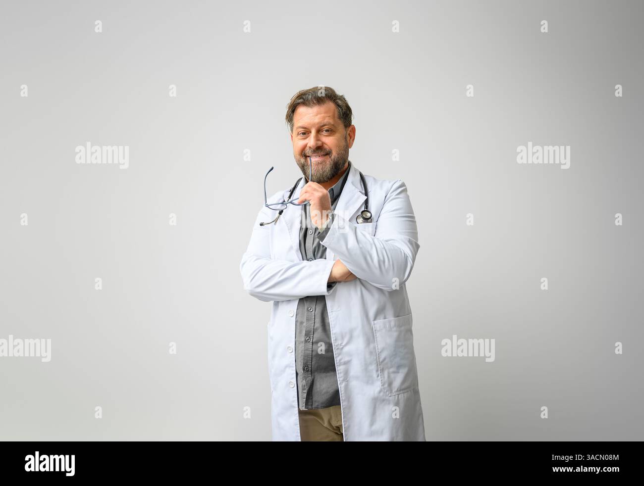 Ritratto di un medico sorridente in un camice da laboratorio con occhiali su sfondo bianco isolato Foto Stock