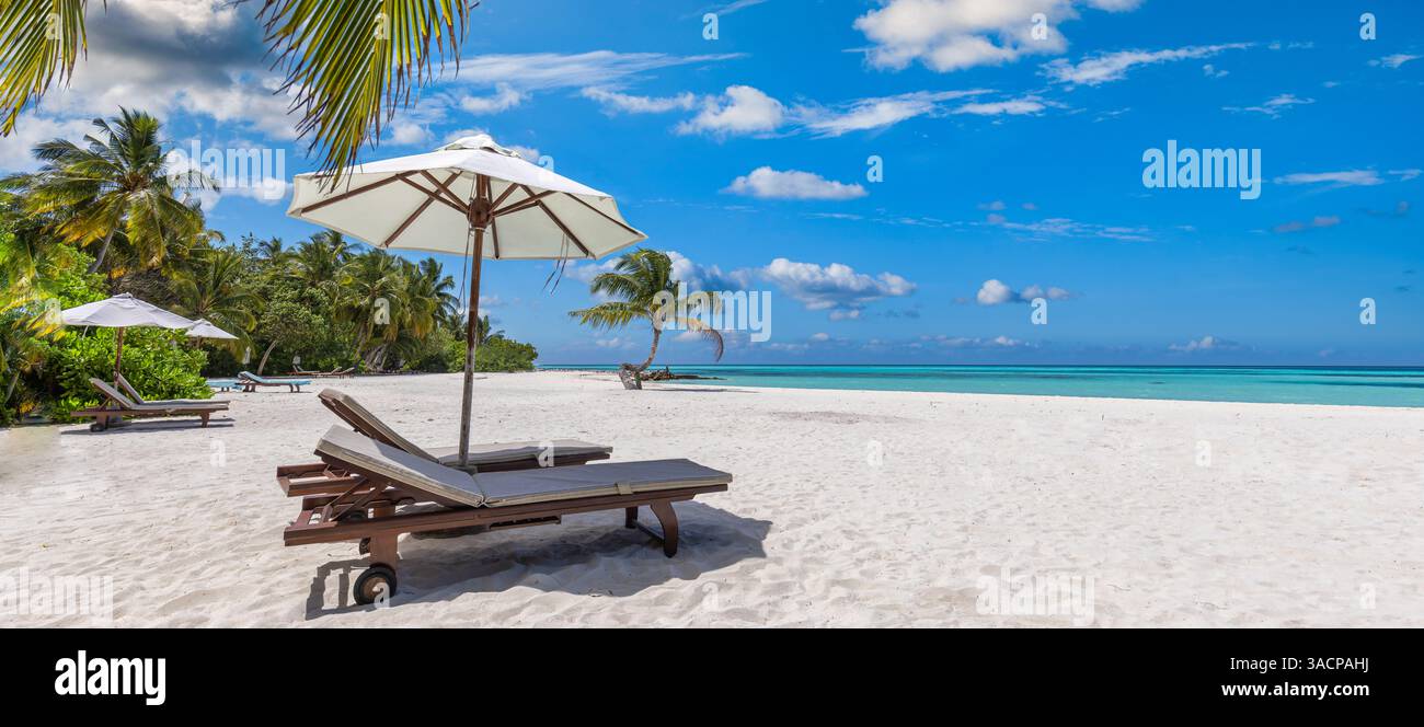 Spiaggia tropicale con sedie, ombrellone, sabbia marina soleggiata, acque cristalline, cielo sereno, luogo di vacanza perfetto per rilassarsi, panorama estivo tranquillo Foto Stock