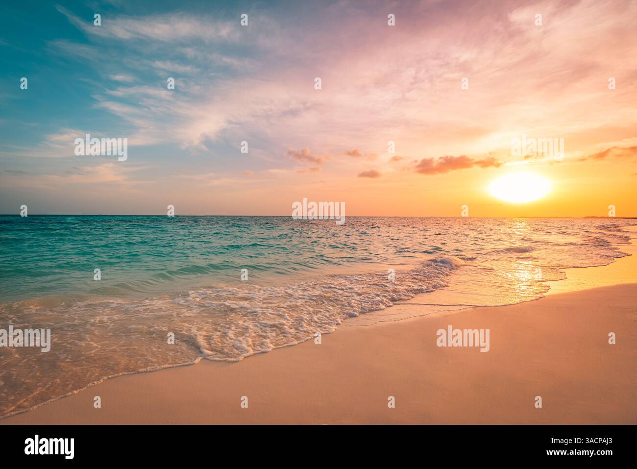 Spiaggia tropicale al tramonto, cieli vibranti che si riflettono sulla sabbia di acqua calma, onde dolci spruzzano la riva, atmosfera serena sotto il cielo colorato, mare tranquillo Foto Stock