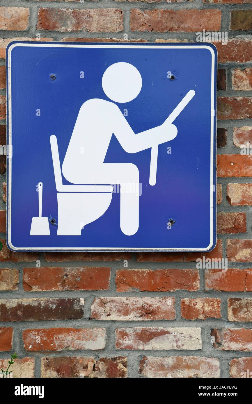 Pittogramma: Persona seduta in bagno a leggere il giornale Foto Stock