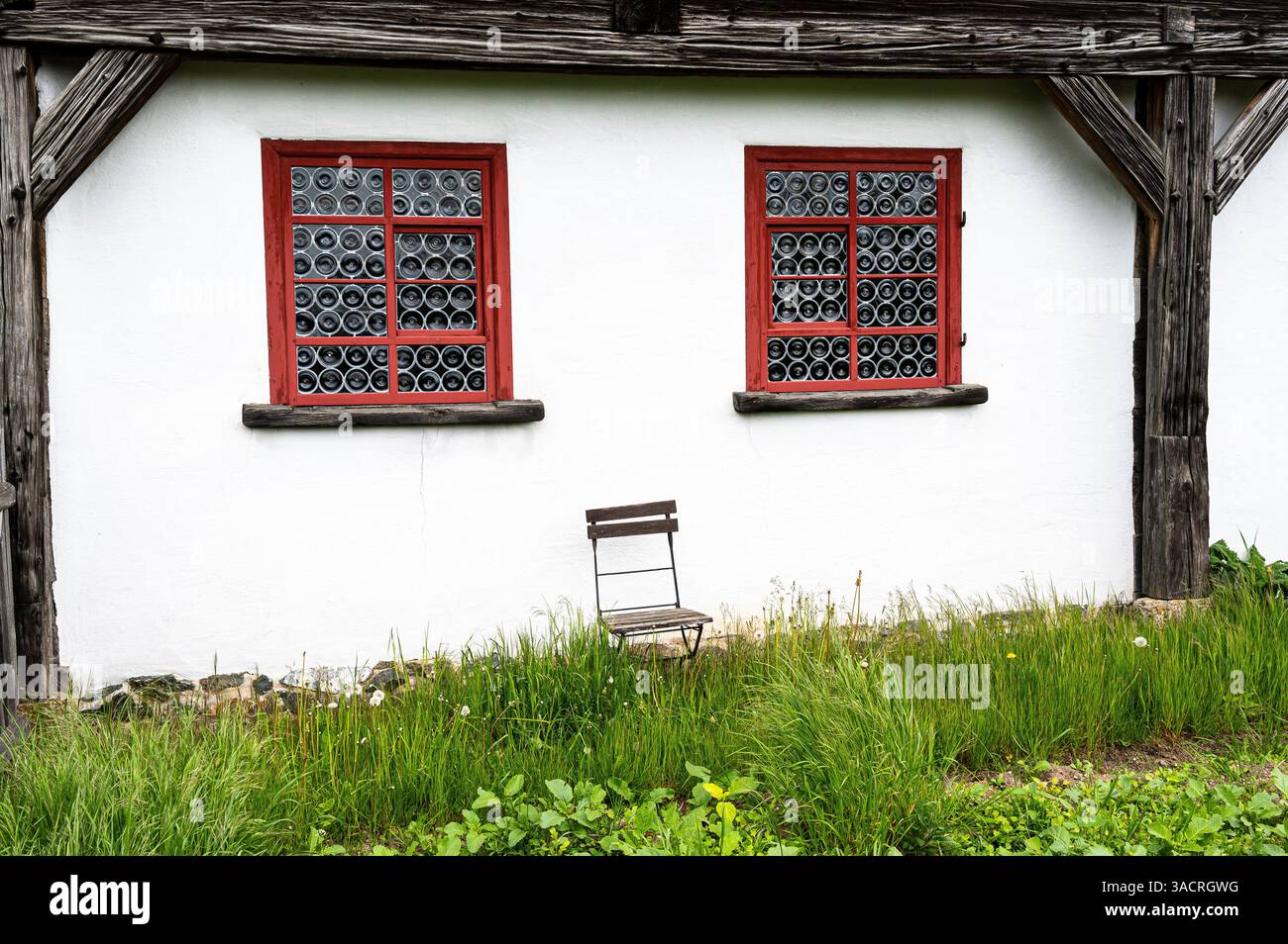 Vecchia casa colonica con sedia e due bellissime vetrate colorate - Hohenfelden, Turingia Foto Stock