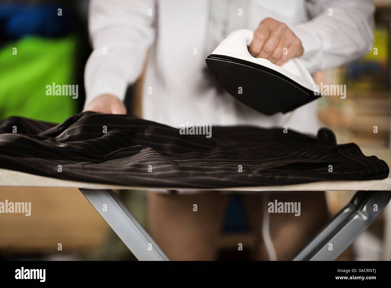 Uomo d'affari che stirava i pantaloni Foto Stock