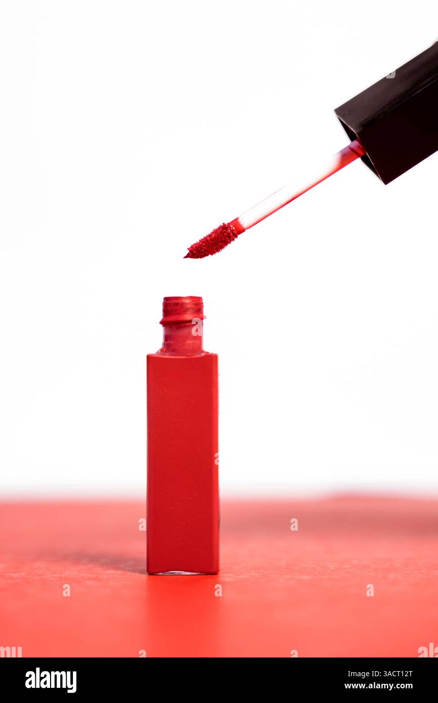 Lucidalabbra rosso-rosato su sfondo bianco e rosa. Ideale per presentazioni di prodotti di bellezza e pubblicità. Foto Stock