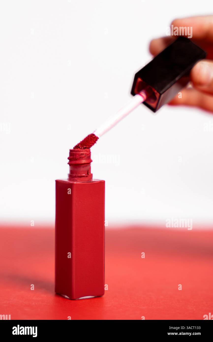 Lucidalabbra rosso-rosato su sfondo bianco e rosa. Ideale per presentazioni di prodotti di bellezza e pubblicità. Foto Stock