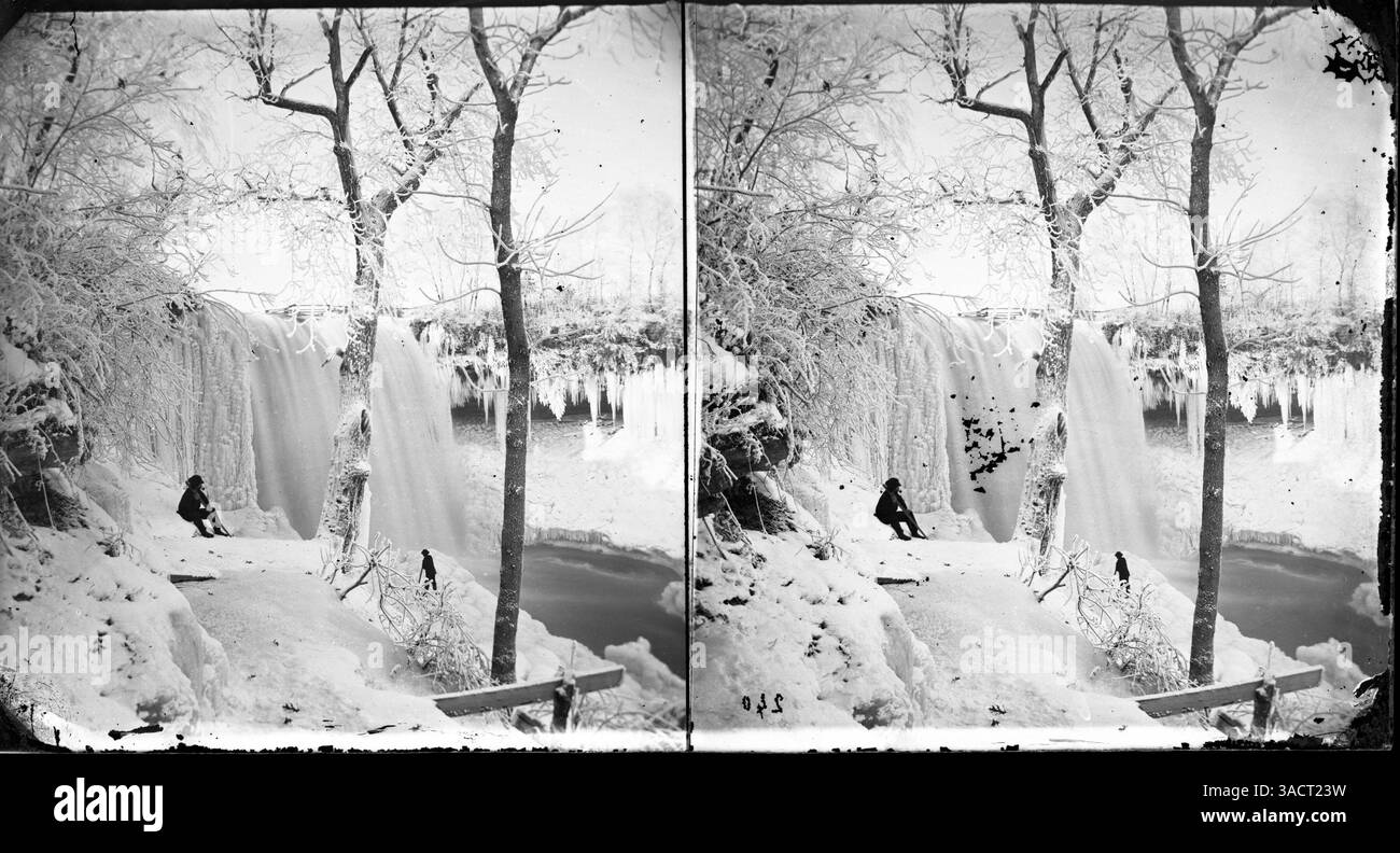 Le cascate di Minnehaha durante l'inverno vengono catturate con rami di alberi ricoperti di ghiaccio, mentre due uomini appaiono sul sentiero. Nonostante il freddo, le cascate rimangono fluenti, mostrando un bel contrasto degli effetti dell'inverno sulla natura. Foto Stock