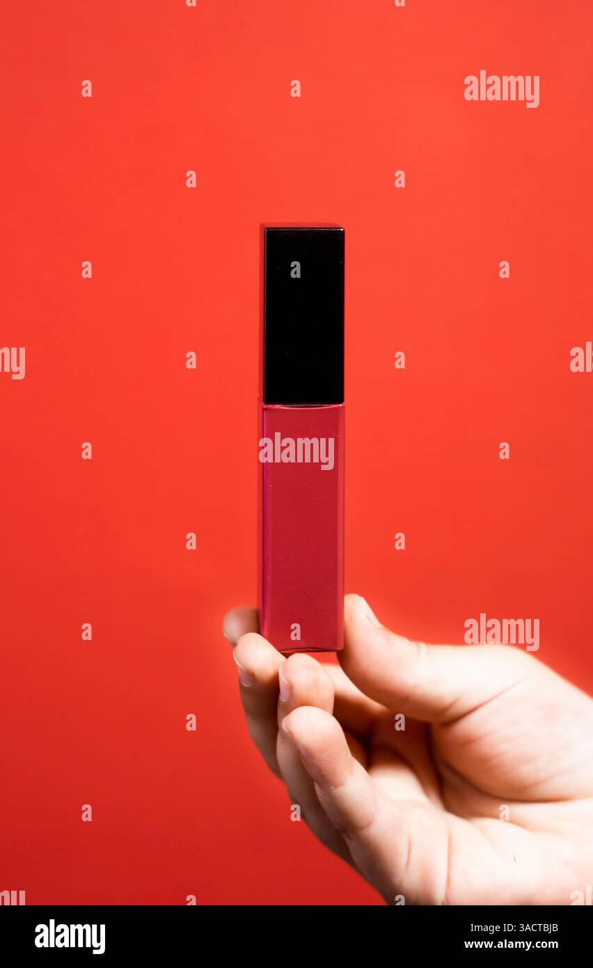 Una ragazza con un lucidalabbra rosso rossastro, ideale per presentazioni di prodotti di bellezza e pubblicità lifestyle. Foto Stock