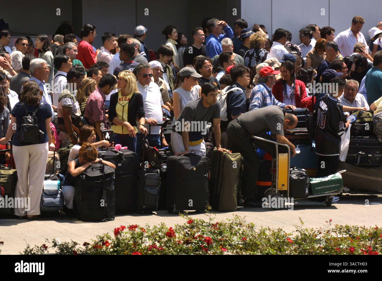 4 luglio 2002; Los Angeles, CA, Stati Uniti; MAGS USA IN USCITA FINO ALL'8 LUGLIO 02!! I passeggeri bloccati attendono accanto al terminal internazionale Tom Bradley, dove è avvenuta una sparatoria vicino alla biglietteria della EL AL Airlines a L.A.X.. (Immagine di credito: Jonathan Alcorn/ZUMAPRESS.com) Foto Stock